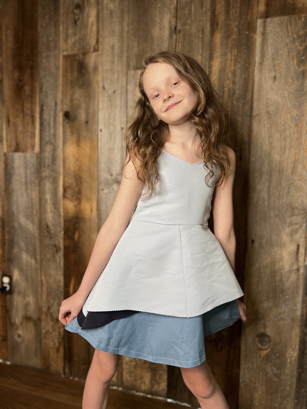 Young designer in a layered peplum dress she made