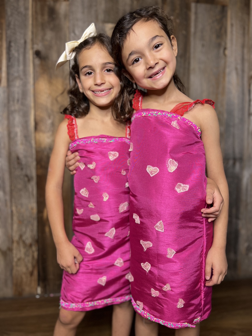Young designers in heart-print dresses they made